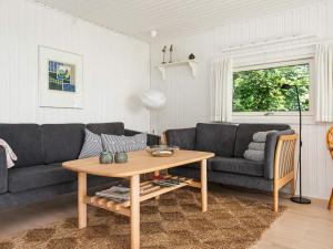 ein Wohnzimmer mit einem Sofa und einem Tisch in der Unterkunft 6 person holiday home in Bjert in Binderup Strand