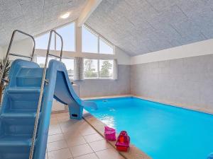 a swimming pool with a slide in a room at 18 person holiday home in Grenaa in Grenå