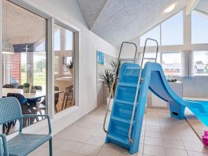 a blue slide in a room with a dining room at 18 person holiday home in Grenaa in Grenå