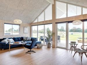 - un salon avec un canapé bleu et une table dans l'établissement 18 person holiday home in Grenaa, à Grenå