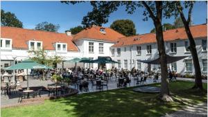 a group of people sitting at tables in a courtyard at Hotel Hoevevoorde in Rijswijk