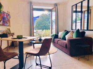 ein Wohnzimmer mit einem Sofa und einem Tisch in der Unterkunft Appartement T2, vue lac, climatisé, parking, tout confort in Aix-les-Bains