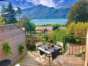 een balkon met een tafel en stoelen en uitzicht op een meer bij Appartement T2, vue lac, climatisé, parking, tout confort in Aix-les-Bains