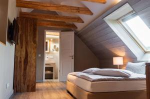 Schlafzimmer mit einer gewölbten Decke, einem Bett und einem Fenster in der Unterkunft StrandBerg's Stadt Chalet in Braunlage