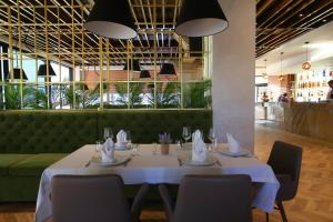 a dining room with a table and a green couch at Portik Hotel in Berat