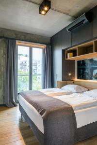 - une chambre avec un grand lit et une grande fenêtre dans l'établissement Downtown Apartments Mitte, à Berlin