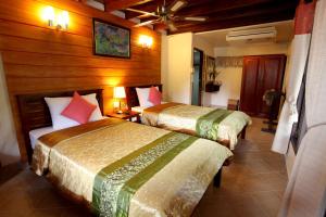 two beds in a hotel room with wooden walls at Ao Nang Home Stay - Adults Only in Ao Nang Beach