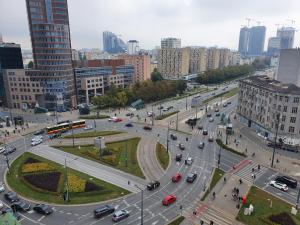 une rue urbaine animée avec circulation dans une ville dans l'établissement Alma Apartments Rondo ONZ, à Varsovie