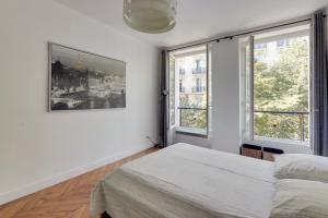 パリにあるThe BEST DEAL in the MARAIS - 1Bedroom Apt - 45m2のベッドルーム1室(ベッド1台、窓2つ付)