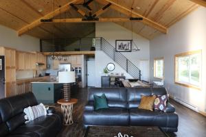 a living room with a leather couch and a kitchen at Canyon Pines Retreat in Thayne