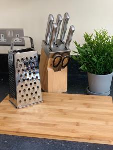 a knife block with a pair of scissors on a cutting board at Three Bedroom Townhouse with Parking in Telford