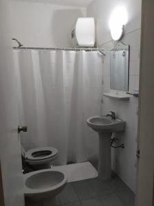 ein weißes Bad mit einem WC und einem Waschbecken in der Unterkunft Posada de Britopolis in Colonia Valdense