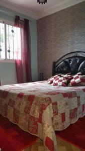 Location Vacances Casablanca Tamaris في الدار البيضاء: غرفة نوم عليها سرير ولحاف