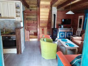 uma cozinha e sala de estar num chalé de madeira em Apartment Bajka em Mokra Gora
