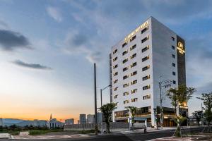 蔚山的住宿－Brown-Dot Hotel Ulsan-Sincheon，一座高大的白色建筑,上面有时钟