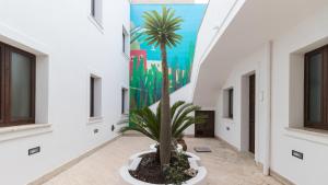 a palm tree in a hallway with a mural on the wall at Italianway - Ottoventi Apartments in Lampedusa