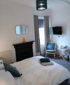 a bedroom with a large white bed and a chair at Rosalind House in Carlisle
