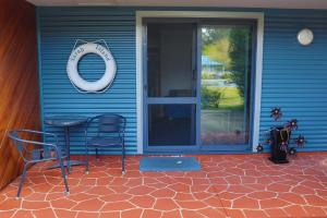 a blue bench sitting in front of a blue door at Strahan Bungalows in Strahan