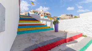 a group of colorful stairs with a flag on a building at Italianway - Ottoventi Apartments in Lampedusa