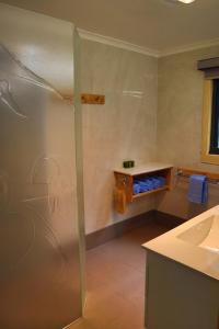 uma casa de banho com um chuveiro e um lavatório. em Strahan Bungalows em Strahan