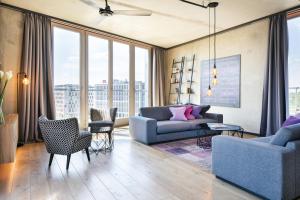 sala de estar con sofá, sillas y ventanas en Downtown Apartments Mitte en Berlín