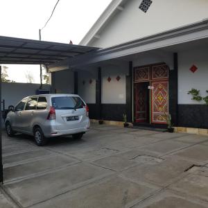 une voiture garée dans un parking en face d'une maison dans l'établissement Hotel Bundo Permai 1, à Pacitan