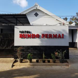 un panneau indiquant un hôtel mundo pennana avec des plantes en pot dans l'établissement Hotel Bundo Permai 1, à Pacitan