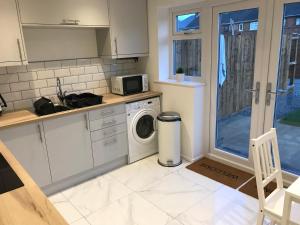 a kitchen with a washing machine and a microwave at Property Hunter 25 in Darlington