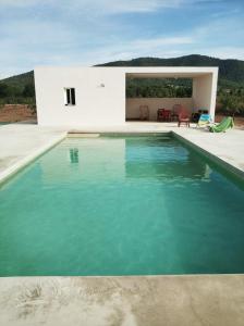a swimming pool in front of a white house at Casa para tres hermanas in Bullas