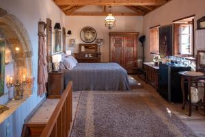 a bedroom with a bed and a table and a clock at CASA FELICIA-The Castle Mansion in Monemvasia