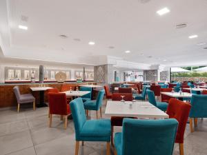 un restaurante con mesas blancas y sillas azules en Aparthotel Aquasol, en Palmanova