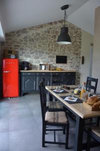 cocina con mesa de madera y nevera roja en B&B LE BORDAGE, en Mortagne-sur-Sèvre