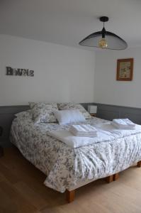 um quarto com uma cama com um cobertor e um candeeiro em B&B LE BORDAGE em Mortagne-sur-Sèvre