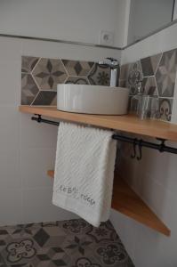 a bathroom with a sink and towels on a shelf at B&B LE BORDAGE in Mortagne-sur-Sèvre