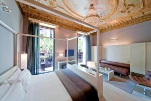 sypialnia z łóżkiem i kasetonowym sufitem w obiekcie Hotel Actual w Barcelonie