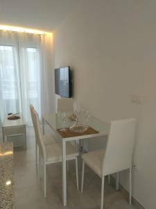 a dining room with a white table and chairs at TURISMO LOS LANCES TARIFA( PARKING GRATUITO) in Tarifa