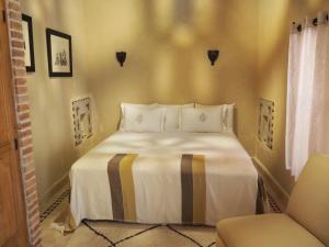 - une chambre avec un lit et une chaise dans l'établissement Riad Les Trois Palmiers El Bacha, à Marrakech