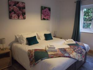- une chambre avec un grand lit et des serviettes dans l'établissement Stable Cottage, à Redlynch