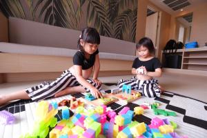 two young girls playing with blocks on the floor at Panan Krabi Resort - SHA Plus in Ao Nang Beach
