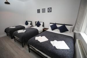 a room with three beds with towels on them at Golders Park Hotel in London