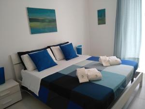 a bedroom with a blue and white bed with blue pillows at Maccone Bianco in Santa Maria Del Focallo