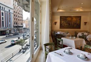 a restaurant with a large window overlooking a city at Hotel Atlántico in Madrid