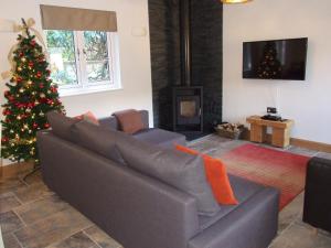 een woonkamer met een kerstboom en een bank bij Stable Cottage in Redlynch