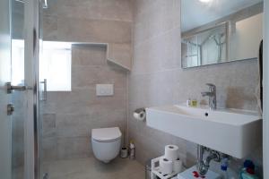 a bathroom with a sink and a toilet and a mirror at Apartment Lassy by Irundo in Rovinj +18 photos