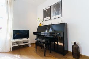 a black piano in a living room with a television at Apartment Lassy by Irundo in Rovinj
