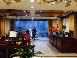 a lobby of a hotel with a man and a child in the lobby at Cedar peak unit 608 in Baguio