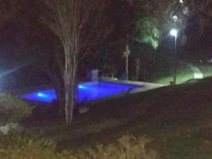 una piscina por la noche con luces azules en Pousada Céu de Luz en Itapeva