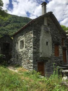 una vieja casa de piedra al lado de una colina en Rustico Ca d'Damunt, en Cevio