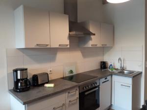 a kitchen with white cabinets and a counter top at FerienRemise in Brandenburg an der Havel