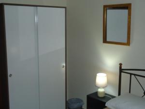 une porte de placard en verre dans une chambre avec une lampe dans l'établissement Original house, à Larissa